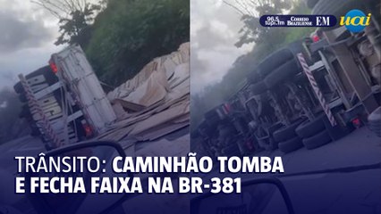 Caminhão carregado com madeira tomba e fecha faixa da BR-381