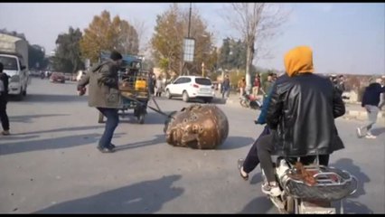 Testa della statua di Assad trascinata dai ribelli per le vie di Hama