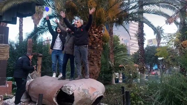 سوريون يشوهون تمثالا للرئيس الراحل حافظ الأسد في وسط دمشق