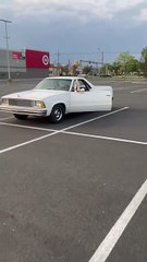 Guy is just chilling in an El Camino with extremely pointy toe boots on!