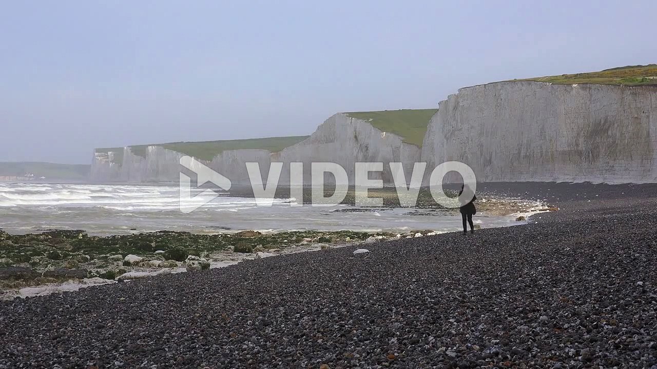 A woman walks along the White Cliffs of Dover near Beachy Head in Southern England