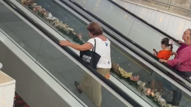 Lady walks upward on moving walkway without realizing it’s moving downward