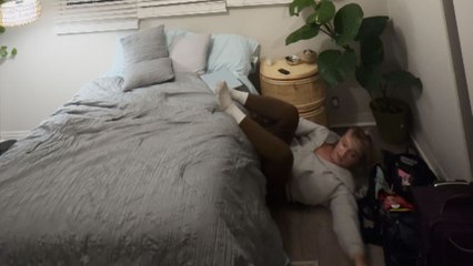 Girl falls off the bed while playing hide and seek with her dog