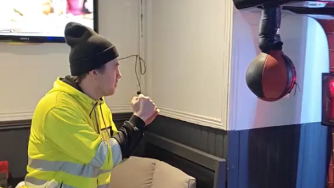 Boy punches boxer arcade machine with all his m...