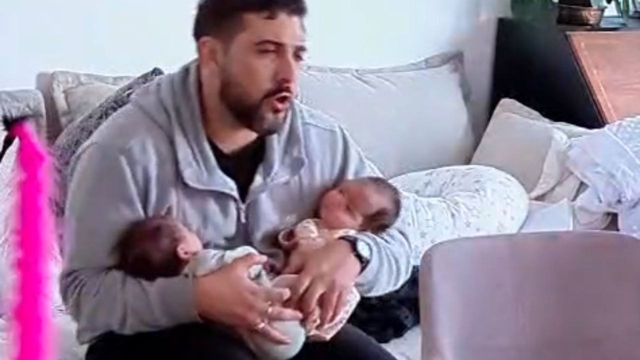 Dad sings to calm his restless twins during his wife's short absence