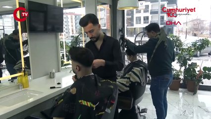 Müşterilerini, omzunda iguana ile tıraş ediyor