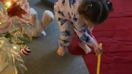 Little girl pushes bauble with stick and it mysteriously vanishes into thin air