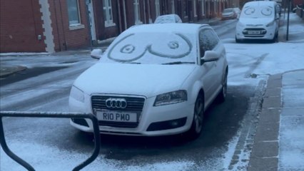 Eye doodles on snow-covered windscreens of cars as winter sets in