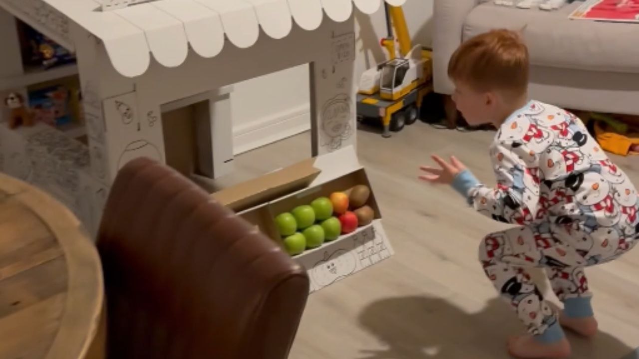 Excited five-year-old screams with joy over his cardboard shop Christmas gift