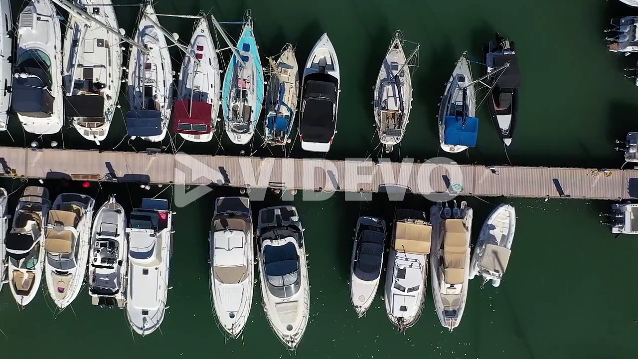 Sailing boats and luxury yachts moored at port, aerial overhead view