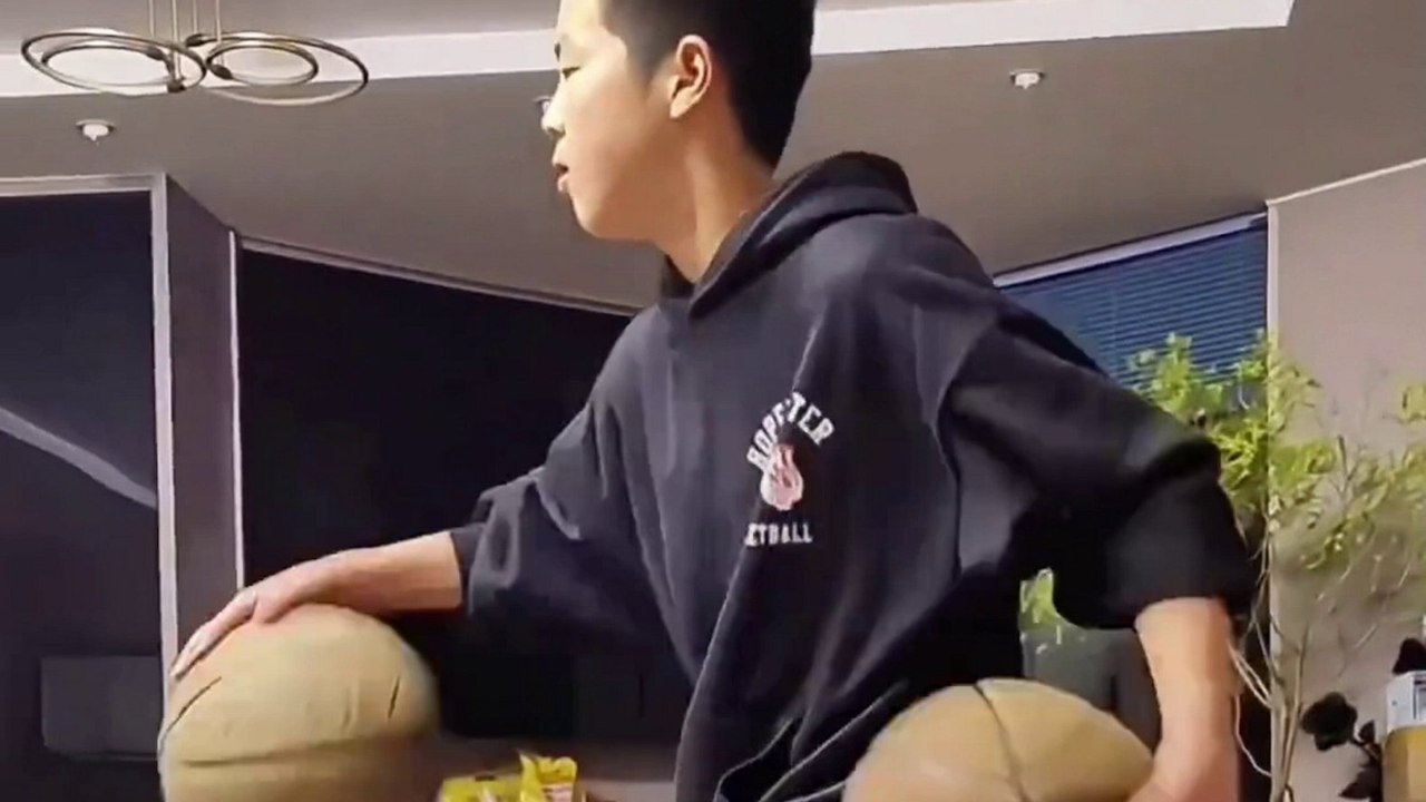 Junge zeigt seine Basketball-Dribbelkünste, während er auf einer Bank hockt