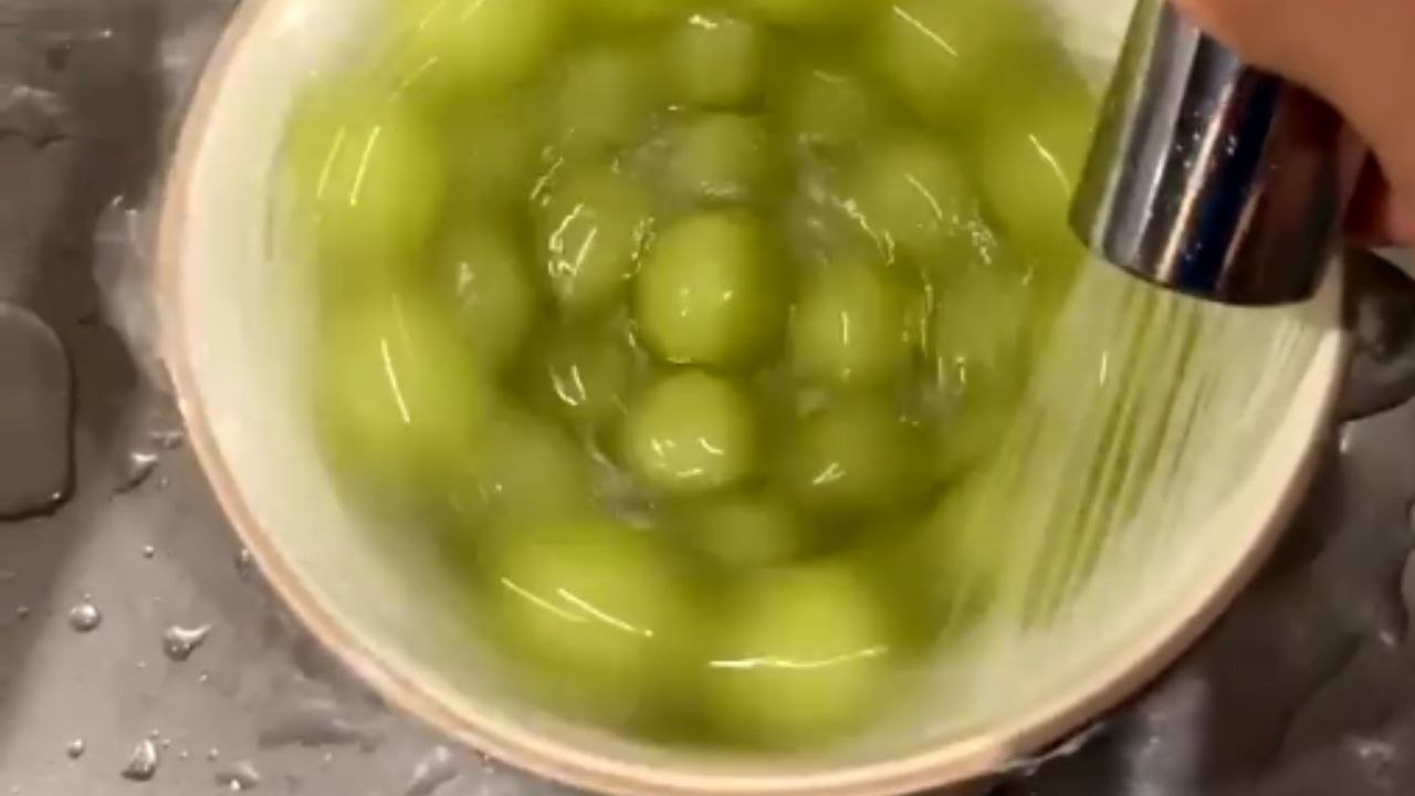 Grapes spin in a bowl as water flows over them