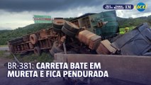 Carreta bate em mureta, fica pendurada e fecha a BR-381