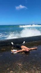 Man Stumbles on Beach and Gets Soaked by Incoming Wave