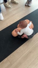 Un niño simula una RCP a un maniquí en un curso de primeros auxilios