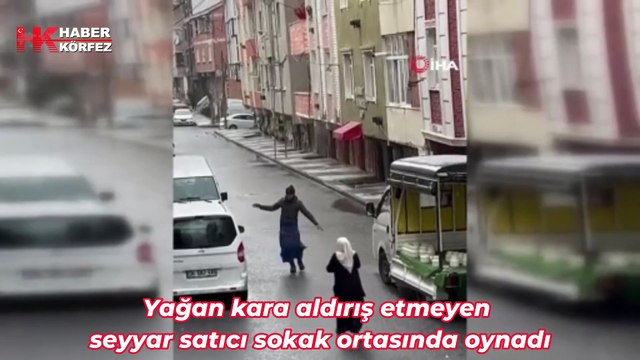 Yağan kara aldırış etmeyen seyyar satıcı sokak ortasında oynadı