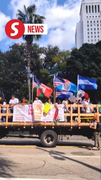 Demonstrators march down Los Angeles street to protest against immigration raids