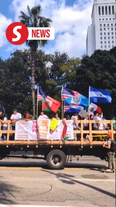 Demonstrators march down Los Angeles street to protest against immigration raids