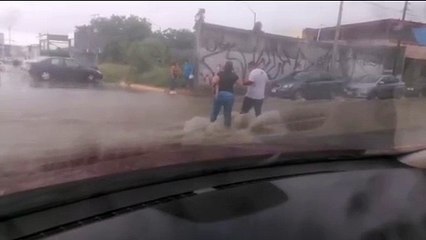 Personas arriesgan su vida para cruzar avenida inundada (VIDEO)