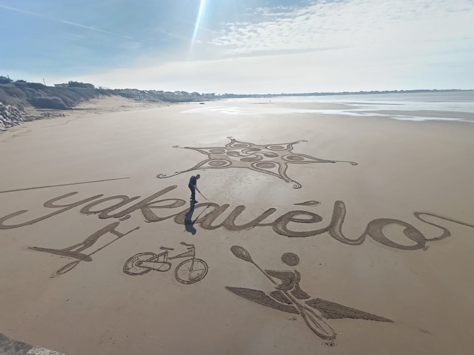 Un artiste trace des dessins sur le sable à Saint-Michel-Chef-Chef