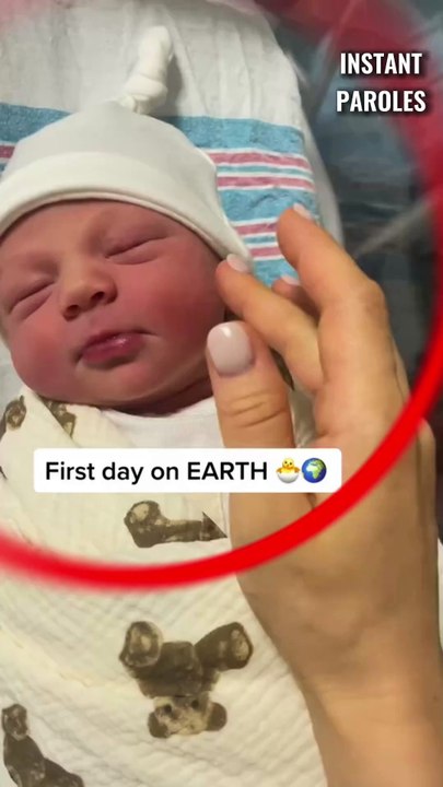 Ce bébé venant de naître sourit lorsque sa maman lui caresse la joue