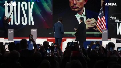 Musk sul palco con una motosega, regalo del presidente argentino Milei