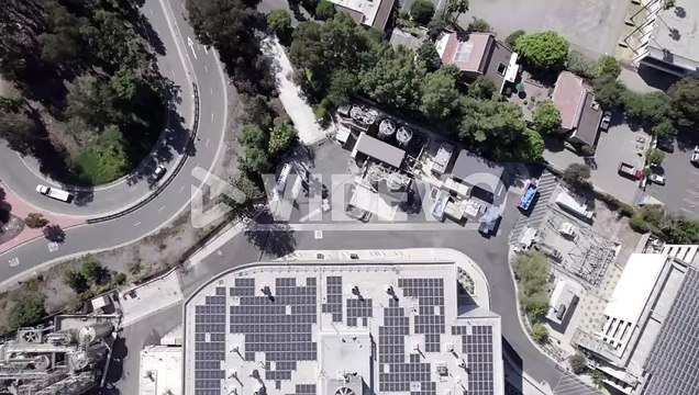 Eco-Friendly green energy solar panels on roof of large commercial ,building, top down aerial view