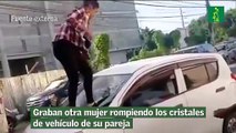 Graban otra mujer rompiendo los cristales de vehículo de su pareja