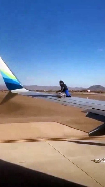 Man climbs onto the wing of a plane waiting for take-off after breaking into a Las Vegas airport runway area