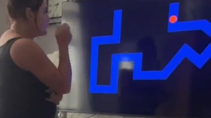 Woman screams loudly when an eerie figure appears on TV screen