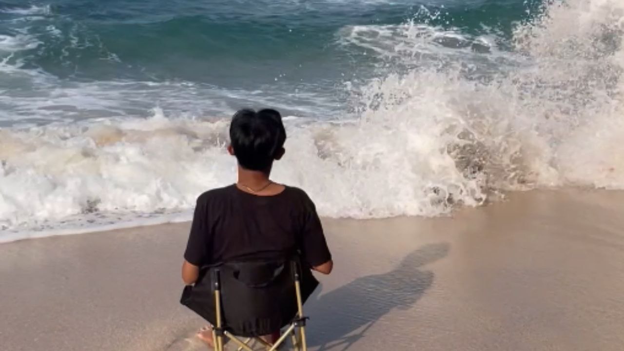 Boy gets knocked over by a wave while trying to film a video