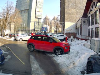 Man Helps Push Red Car Stuck in Snow