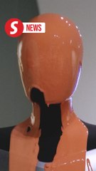 Activists pour orange liquid over robot at Elon Musk's Tesla store in London