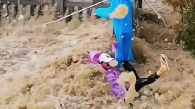 Massive tidal surge sweeps over riverbank - knocking over tourists