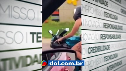 b'Mulher pilota moto usando fio dental'