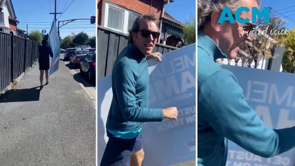 Monique Ryan's husband tears down Liberal Kooyong candidate's sign