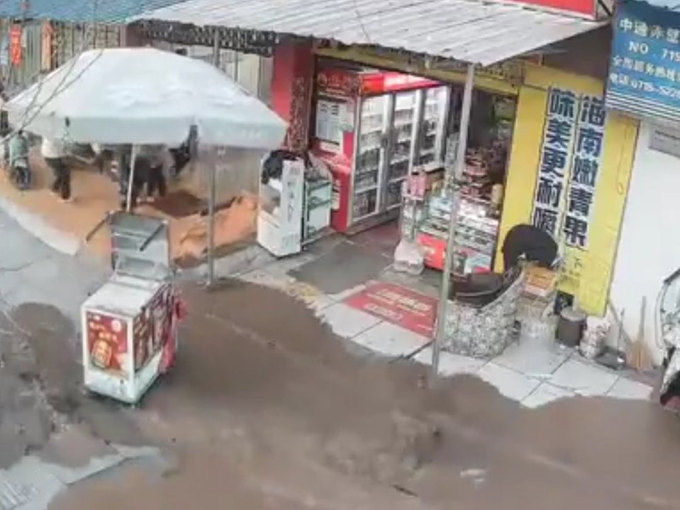 Braune brühe flutet straße: menschen fliehen in panik