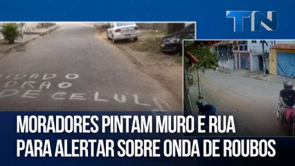Moradores pintam muro e rua para alertar sobre onda de roubos