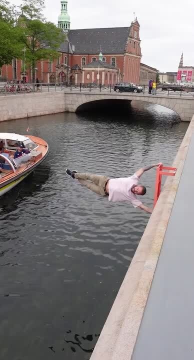 Man Grabs Ladder and Balances Himself While Lifting Like Flag