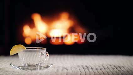 Pour Tea Into A Cup On The Background Of The Fireplace Tea In A Cozy Setting