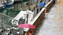 Η Κλέλια Ανδριολάτου περπατάει στην Βενετία με μία κόκκινη ομπρέλα