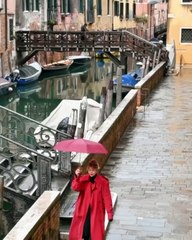 Η Κλέλια Ανδριολάτου περπατάει στην Βενετία με μία κόκκινη ομπρέλα