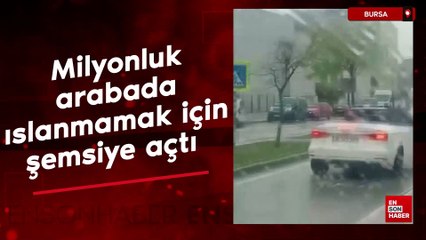 Bursa'da milyonluk arabada ıslanmamak için şemsiye açtı