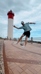 Man Performs Freestyle Soccer Dribble Near Lighthouse