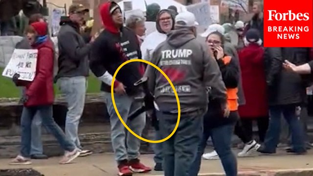 Man Wearing Trump Hoodie, Brandishing Rifle, Confronts Anti-Trump Protestors At 'Hands Off' March