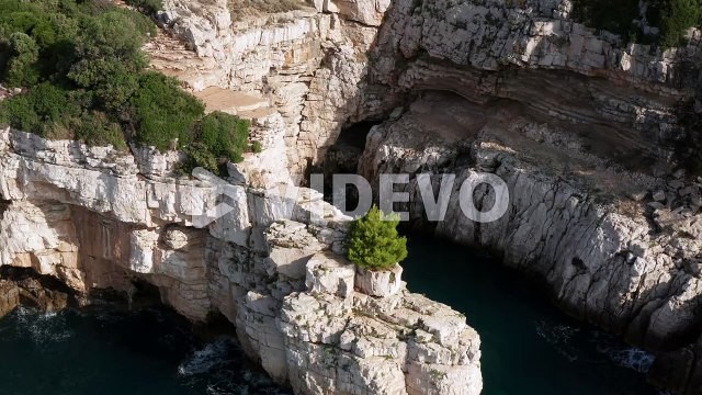 Tourists Kayaking Near The Cliffs And Caves Of Pula Istria, Croatia In Europe