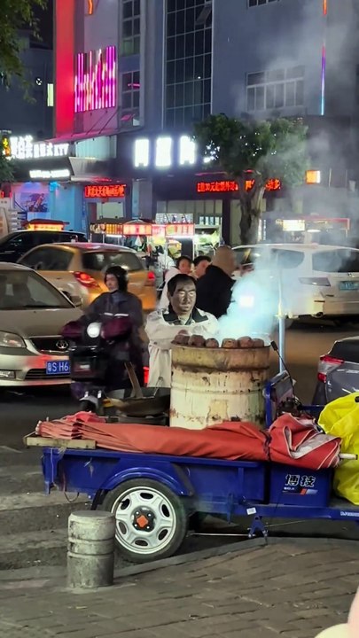 A middle-aged person selling baked sweet potatoes