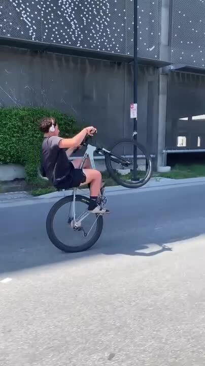 Person Loses Balance While Doing Wheelie and Collides With Car Approaching From Behind