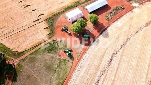 Drone birds eye view of agricultural machines waiting to go harvest wheat