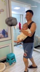 Dad Laughs With Baby Playing a Balloon-Kick Game With a Trash Bag